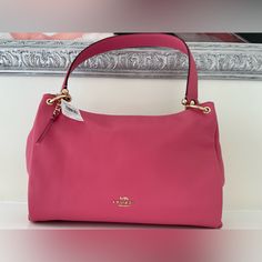 Coach Leather Shoulder Bag,Pink And Gold Hardware ,Interior Pink Fabric Lining With A Slip Pocket That Has Embossed Creed That Reads A1923-F28966 Gold Hardware In Exterior With Braided Gold Zipper ,Handle With 8 3/4”Drop Detachable Strap With 20”Drop For Shoulder Or Crossbody Wear Classic Pink Top Handle Satchel, Classic Pink Leather Bag, Pink Textured Leather Top Handle Bag, Pink Top Handle Bag With Textured Leather, Pink Textured Leather Rectangular Bag, Chic Pink Textured Leather Shoulder Bag, Classic Pink Shoulder Bag For Evening, Pink Soft Leather Rectangular Satchel, Pink Leather Bag For Formal Occasions