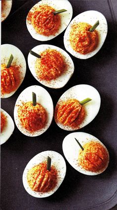 deviled eggs are arranged on a black tray