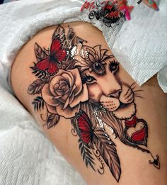 a woman's thigh with roses and a lion tattoo on it