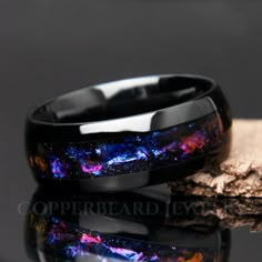 "This black galaxy ring is gorgeous! It features a mesmerizing design reminiscent of swirling gas and dust clouds found in galaxies, this ring boasts a stunning array of colors that evoke the celestial splendor of the night sky. Deep blues, purples, pinks, and oranges come together in a breathtakingly beautiful pattern, creating a sense of cosmic movement and dynamism that is sure to captivate the imagination. Beautiful color shifting effect! || Features || - Solid and strong tungsten band - Dom Space-themed Black Jewelry Gift, Galaxy Rings, Promise Ring Men, Stars Beautiful, Fantasy Jewelry Magic, Blue Sandstone Ring, Sandstone Ring, Cosmic Ring, Ceramic Wedding