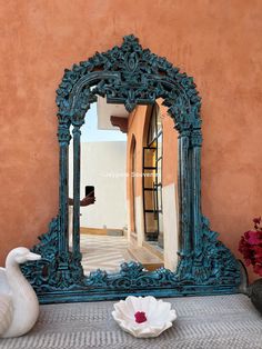 an ornate blue mirror sitting on top of a bed