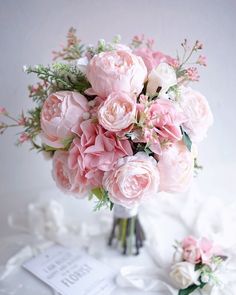 a bouquet of pink flowers sitting on top of a table