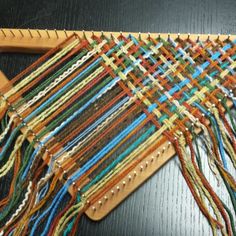 a weaving machine with many different colored threads on it