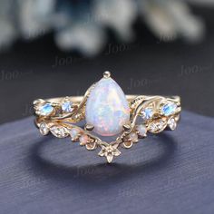 Nature Inspired  Jewelry, Twig Opal Ring Set , 10K Gold, Teardrop Ring, Branch Engagement Ring, Moonstone Wedding Ring , October Birthstone, Birthday Gifts Main Ring : 6*8mm Pear cut Lab white opal. Side stone : Moonstone Matching Band: Moissanite and opal. Material Metal: 925 sterling silver, Solid 14k/18k gold, platinum PLEASE choose silver or platinum if you are allergic to nickel. This jewelry is made to order, it can be made with any gemstone/metals. 2-3 weeks to finish. Default Shipping me Fairy Wedding Ring Opal, Sun Ring Engagement, Real Opal Engagement Ring, Opal Ring Set, Opal And Aquamarine Ring, Mythical Engagement Ring, Pear-shaped Birthstone Jewelry For Wedding, Fine Jewelry Teardrop Moonstone Wedding Ring, Diamond Opal Ring With Gemstone Accents For Wedding