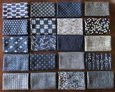 many different types of cloths on a wooden table with white and blue designs in the middle