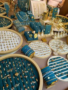 a table topped with lots of blue and gold jewelry