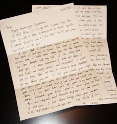 two pieces of paper with writing on them sitting on top of a table next to each other