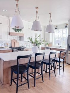 a kitchen island with four chairs in front of it and an oven on the other side