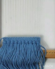 a blue mop sitting on top of a wooden floor next to a window sill