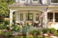 an american flag is hanging on the front porch