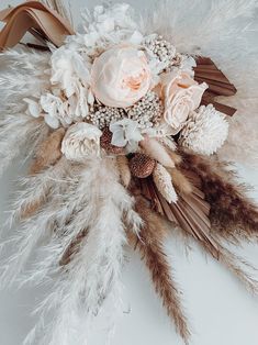 a bridal bouquet with feathers and flowers