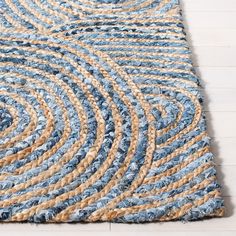 blue and beige braided rug on white wood floor with wooden planks in the background