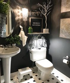 a white toilet sitting next to a sink in a black and white bathroom with checkered flooring