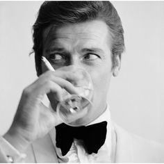 English actor Roger Moore, downs a Martini as James Bond, 17th July 1968. (Photo by Peter Ruck/BIPs/Getty Images)  As an authorized Getty Images Gallery partner, we offer premium quality prints scanned from the original negatives and plates from Getty’s darkroom. All photographic prints are accompanied by a Certificate of Authenticity from Getty Images Gallery.  The B & W resin printing process is a method which is part hand printed and part machine processed on archival paper. An embossed G Roger Moore 007, Shaken Not Stirred, Rudolf Nureyev, Roger Moore, Slim Aarons, Humphrey Bogart, Bond Films, Barbra Streisand, Vogue Covers