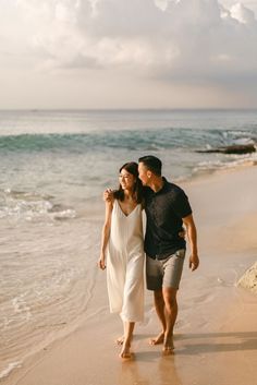 a man and woman walking along the beach