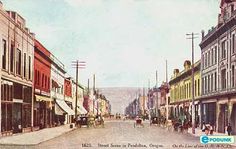 an old postcard shows people walking down the street in front of buildings and horse drawn carriages