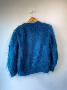 Vintage Alain Murati Ocean Blue Fuzzy Sweater Cardigan. Absolutely stunning ocean blue sweater with two toned teal and blue embroidery designs. Floral designs scatter across the front with a big personality. Inner lining has subtle impressions that only adds to the charm of this statement piece. In excellent vintage condition. Mohair blend. Unmarked size, material is stretchy. Fits a M/L . Hand wash cold. Approx. Measurements: Length: 26" Underarm to underarm: Up to 30" Blue Long Sleeve Winter Cardigan, Blue Long Sleeve Cardigan For Winter, Blue Crew Neck Cardigan For Winter, Blue Winter Cardigan For Layering, Blue Cardigan For Winter Layering, Winter Blue Sweater For Layering, Light Blue Outerwear For Winter Layering, Turquoise Long Sleeve Sweater For Winter, Turquoise Long Sleeve Winter Outerwear