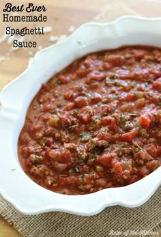 a white bowl filled with red sauce on top of a wooden table