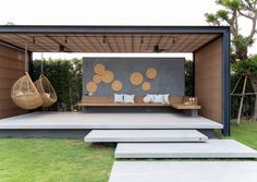 an outdoor living area with concrete steps and hanging chairs