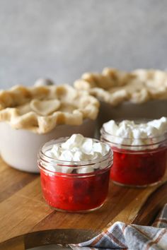 three small pies sitting on top of a wooden cutting board next to each other