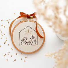 a cross - stitch ornament with a nativity scene on it's side