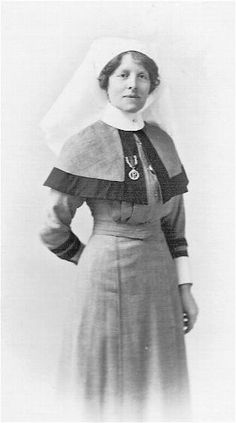 an old black and white photo of a woman wearing a dress with a veil on her head