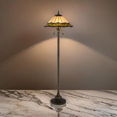 a lamp that is sitting on top of a table next to a light fixture with a glass shade