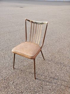 an old chair sitting in the middle of a parking lot with no one around it