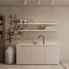 a modern kitchen with white cabinets and shelves