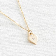 A simple but sweet symbol - this classic heart pendant is bead set with a tiny stone, or left plain. It sits close to the heart, and the back is just waiting to be engraved. Product details: Materials: Solid 14k Gold Pendant and Chain, or Sterling Silver Chain: 18 inches Measures: pendant is 1/2 inches by 3/8 inches Classic Heart-shaped Birthstone Necklace, Classic Heart Pendant Necklace With Birthstone, Classic Heart-shaped Birthstone Jewelry, Classic Heart Shaped Birthstone Jewelry, Delicate Heart Charm Necklace With Round Pendant, Everyday Heart-shaped Single Diamond Jewelry, Everyday Heart Shaped Single Diamond Jewelry, Heart-shaped Yellow Gold Jewelry With Single Diamond, Heart-shaped Sterling Silver Jewelry With Single Diamond