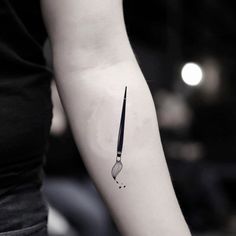 a black and white photo of a knife tattoo on the left arm, with water droplets coming out of it