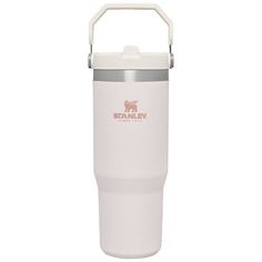 a white shaker cup with a handle on the side and a red sticker that says stanley