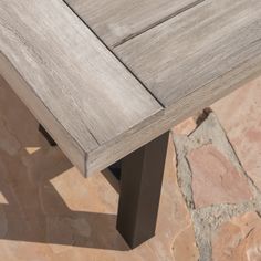 a wooden bench sitting on top of a stone floor