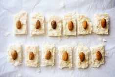 almonds and rice are arranged in rows on a sheet of white paper with some cut up squares