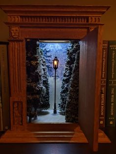 an open doorway with a lamp in the middle and snow on the ground next to it