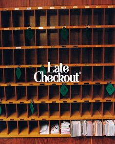 a book shelf filled with lots of books next to a sign that says late checkout