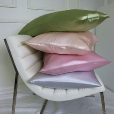 four pillows stacked on top of each other on a chair in front of a door