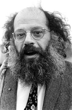 a black and white photo of a man with a long beard wearing glasses, a tie and a suit jacket