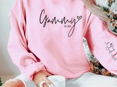 All Grandmas will love this cute Grandma sweatshirt with grandkids names printed on the sleeve!  *Enter Term for front of shirt *Enter Est. date for front of shirt *Enter children's names for sleeve *Example:  Grandma, 2022, Emma, David, Ali, Rebecca * 50% cotton, 50% polyester * Pre-shrunk * Classic fit * 1x1 athletic rib knit collar with spandex * Air-jet spun yarn with a soft feel and reduced pilling * Double-needle stitched collar, shoulders, armholes, cuffs, and hem * Wash inside out in coo Personalized Casual Crew Neck Tops, Long Sleeve Tops With Name Print For Family, Casual Personalized Pink Tops, Casual Personalized Pink Top, Personalized Long Sleeve Casual T-shirt, Casual Personalized Long Sleeve T-shirt, Personalized Casual Long Sleeve T-shirt, Casual Long Sleeve Personalized T-shirt, Personalized Pink Casual Sweatshirt