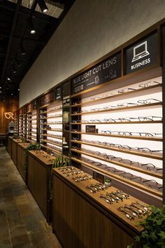 the inside of a store with lots of wooden shelves filled with eyeglasses and plants