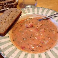 a bowl of soup with bread on the side