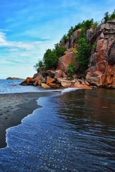 the beach is next to some large rocks