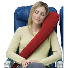 a woman sitting in an office chair with a red pillow on her head and arm