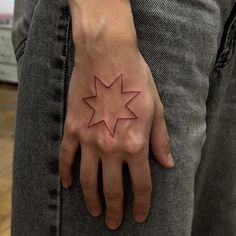 a person's hand with a star tattoo on it