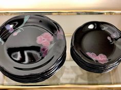 four black plates with pink flowers on them