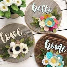 three wooden signs with flowers and the words hello, love, home written on them