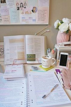 an open book sitting on top of a desk next to a cup of coffee and other items