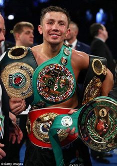 the professional boxer is holding his belts in one hand and smiling at the camera while standing next to him