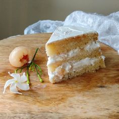 a piece of cake sitting on top of a wooden cutting board next to a flower