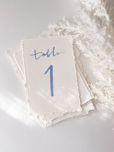 the table numbers are blue and have been placed on top of each other with white feathers